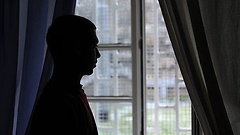 Häftling schaut aus dem Fenster des Jugendgefängnisses