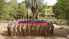 Bundeswehrsoldaten in Koulikoro in Mali mit einer Bundesflagge des Reichstagsgebäudes in Berlin