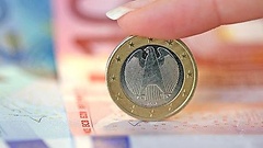 Euroscheine und Eineuromünze mit Bundesadler