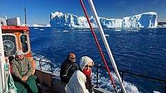 Urlauber an Deck eines Ausflugsbootes zwischen den Eisbergen bei Ilulissat, Diskobucht, Westküste, Grönland