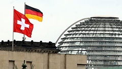 Schweizer und deutsche Fahnen vor dem Reichstagsgebäude