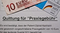 Beleg über die Zahlung der Praxisgebühr liegt unter einem Zehn-Euro-Schein und einer Versichertenkarte