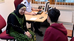 Dolmetscherin Amine Rebmann spricht in der Bundespolizei-Inspektion mit einem Flüchtling aus Syrien. 