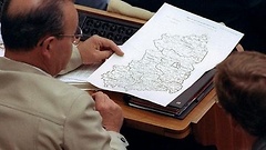 Ein Abgeordneter der DDR-Volkskammer betrachtet am 22.7.1990 eine Karte, auf der die fünf Bundesländer Ostdeutschlands verzeichnet sind.