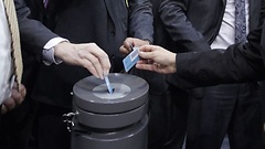 Stimmkarten werden in die Wahlurne gesteckt.