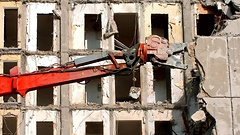 Ein Spezialbagger mit hydraulischer Zange schneidet aus einem der ältesten Hochhäuser von Schwerin eine Betonwand heraus